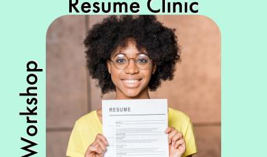 female student smiling and holding up resume